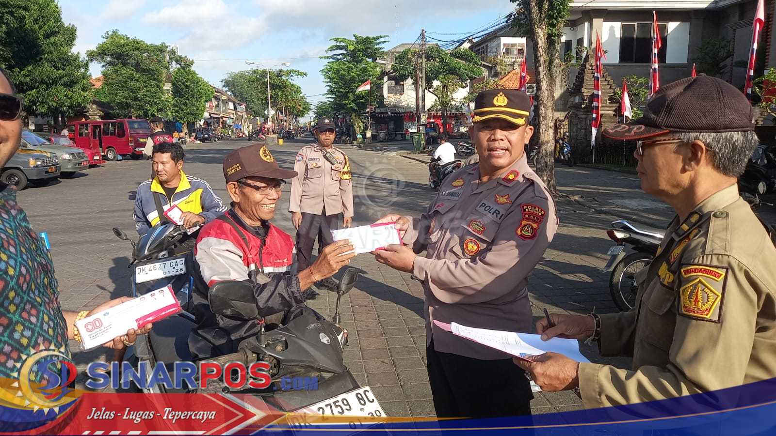 Kapolsek Mengwi Bagikan Bendera Merah Putih Kepada Warga